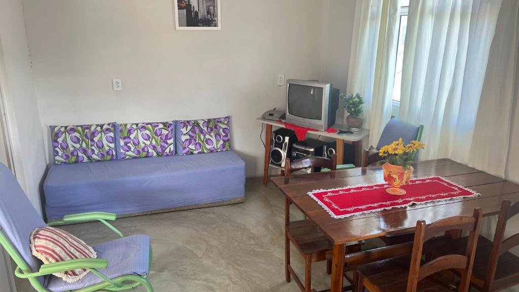 a living room with a table and a couch and a dining room at Apê do NADINHO in Caparaó Velho