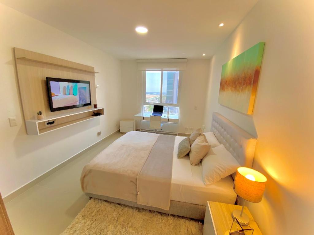 1 dormitorio con 1 cama grande y TV de pantalla plana en Apartamento Oceana 52 - Cerca al Buenavista by SOHO, en Barranquilla