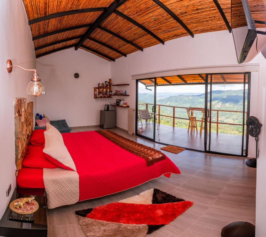 a bedroom with a large red bed and a balcony at GLAMPING SAN GIl TRINIDAD CIELO in San Gil