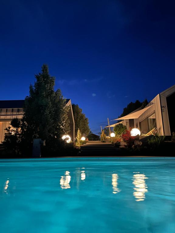 a swimming pool at night with the lights on at SKARPA resort in Ustronie Morskie