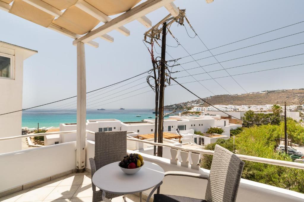 uma varanda com mesa e cadeiras e vista para o oceano em Platis Gialos beach house with sea view balcony em Platis Gialos, Mykonos