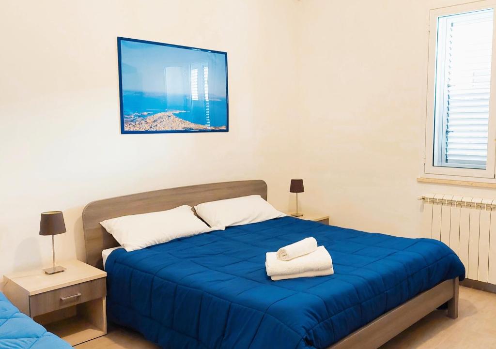 Un dormitorio con una cama azul con toallas. en Casa Granata en Trapani