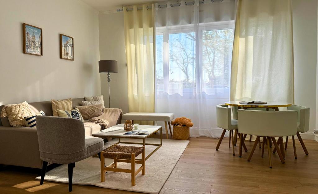 un salon avec un canapé et une table dans l'établissement Les Jardins de la Mer - Appart face Nausicaa, Plage, Netflix, à Boulogne-sur-Mer