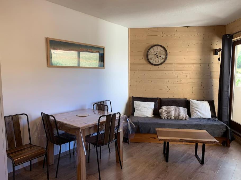 une chambre avec une table, un canapé et un réveil dans l'établissement Joli appartement 6 personnes La Toussuire, à La Toussuire