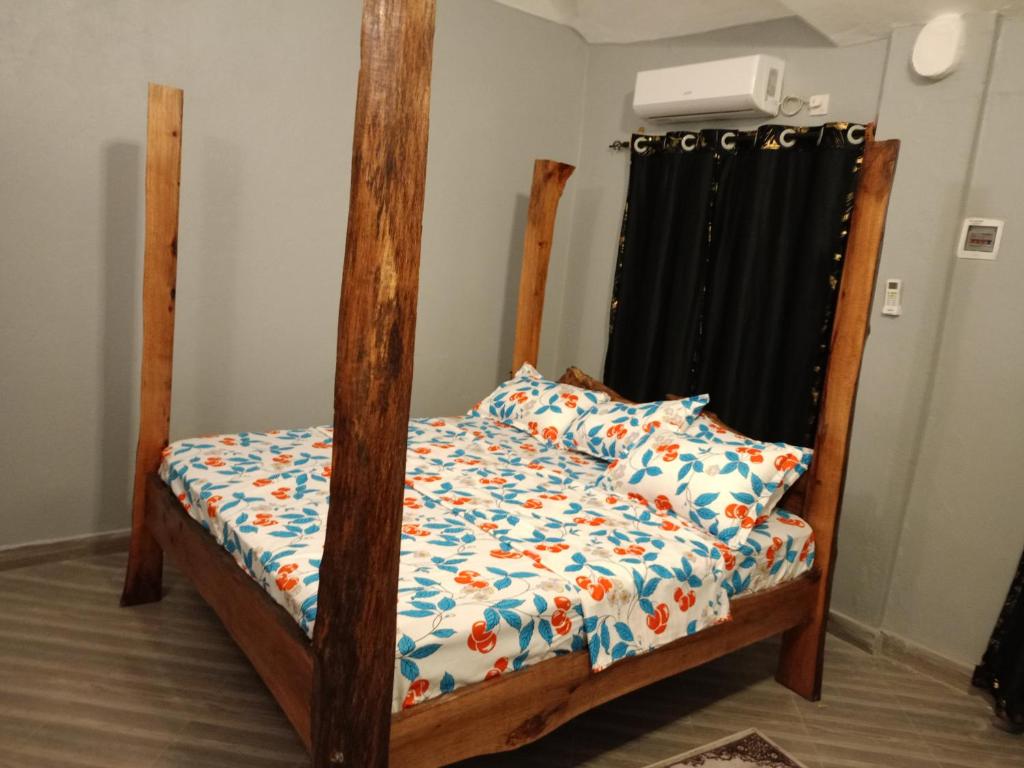 ein Schlafzimmer mit einem Etagenbett aus Holz mit einer Bettdecke in der Unterkunft Opaque gardens in Tezo