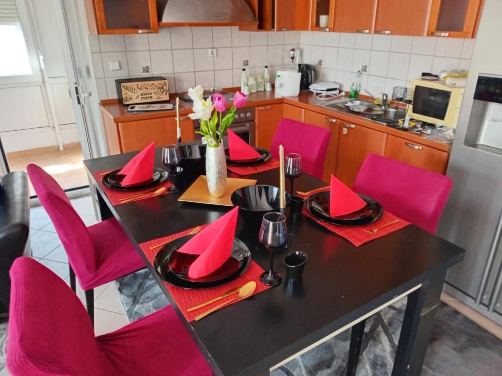 a table with red napkins and red chairs in a kitchen at Layla Home in Alexandroupoli