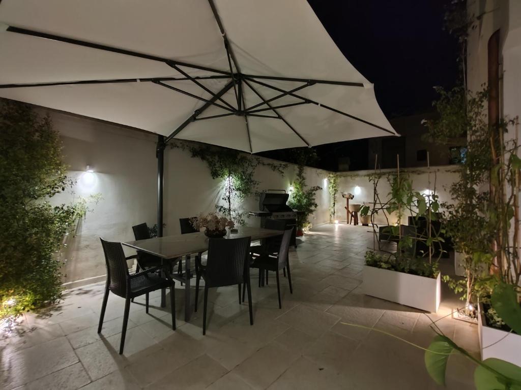 een patio met een tafel en stoelen en een parasol bij Casa Tizy in Botrugno