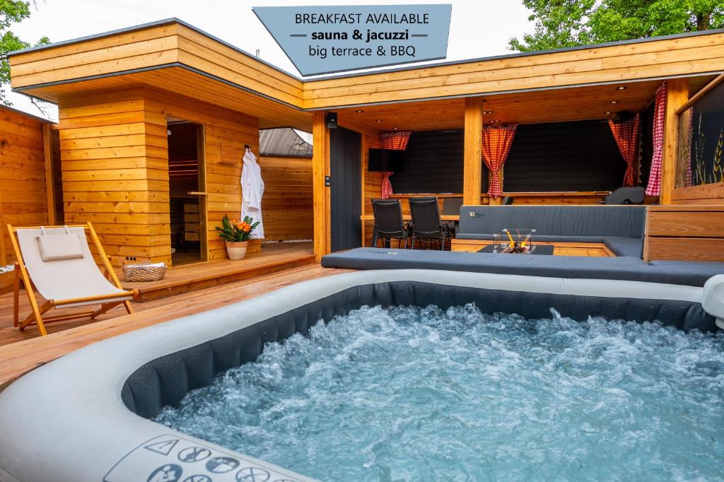 bañera de hidromasaje en la cubierta de una casa en House "HISCA" With Private Terrace, BBQ, Fireplace, Sauna, Hot Tub, en Mozirje