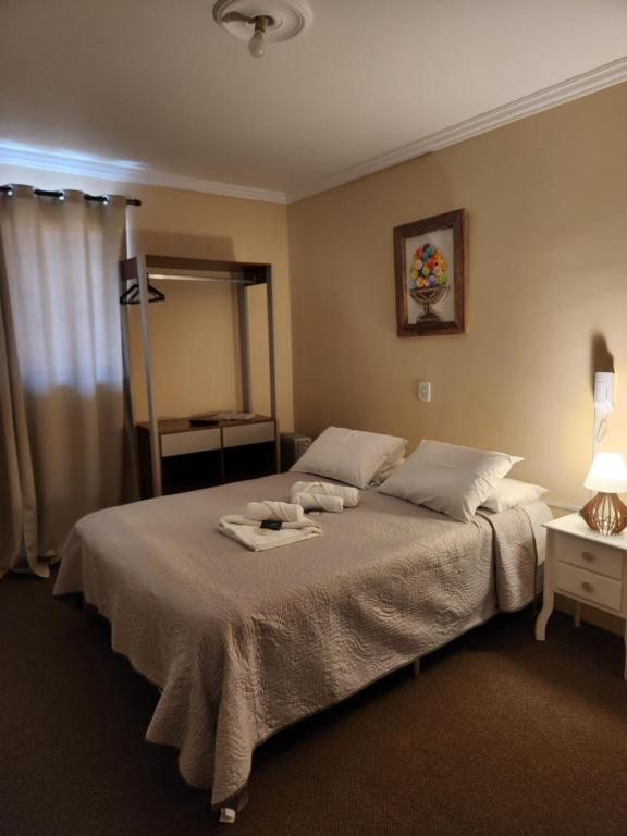 um quarto com uma cama com toalhas em Pousada Araucária em Campos do Jordão