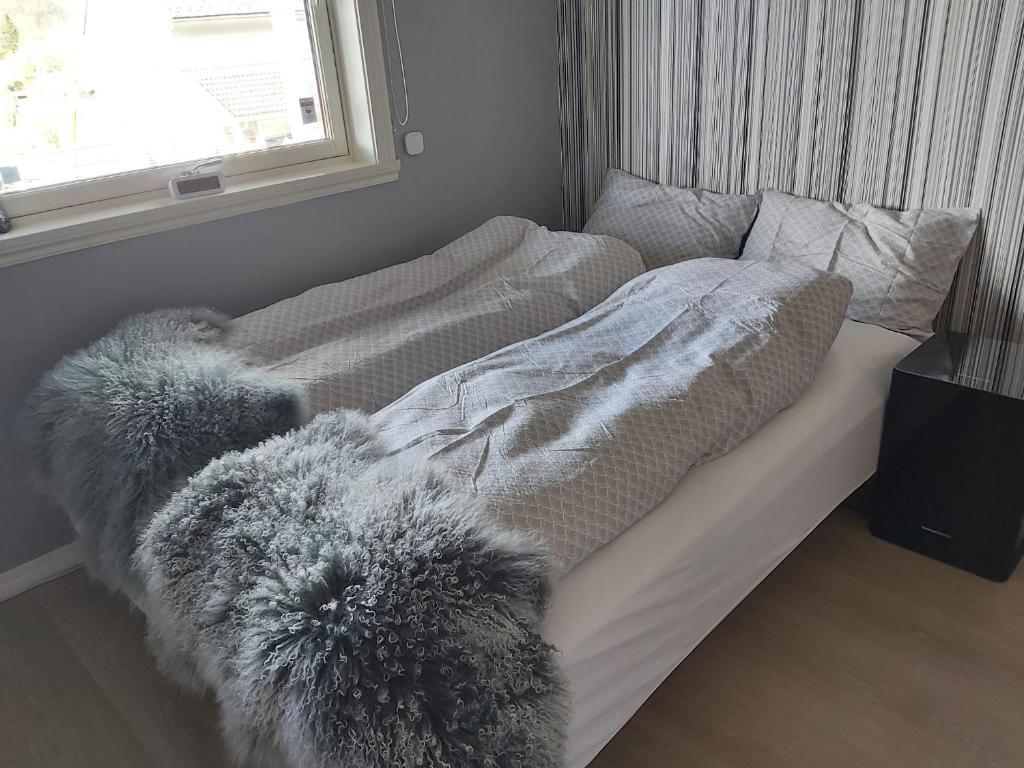 a bed with a blanket and pillows on it at Nearby Bergen in Bergen