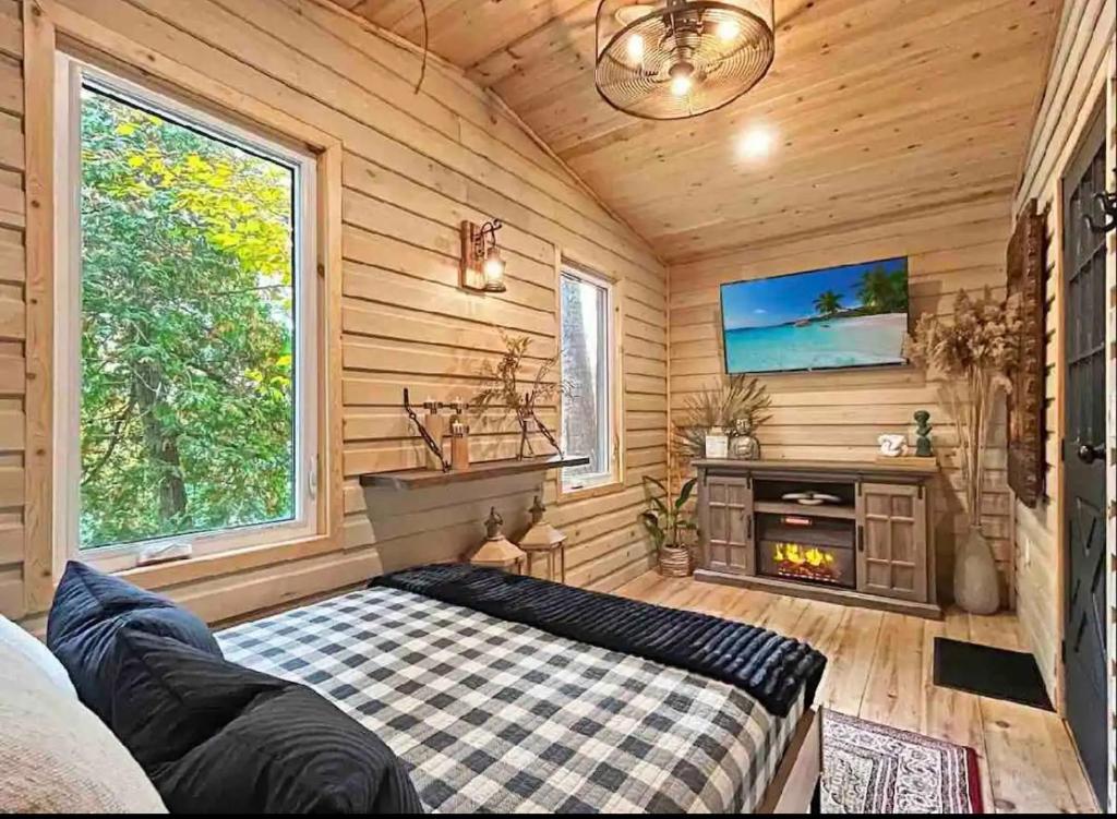 a room with a bed and a fireplace in a log cabin at The Wolfs Den in Bancroft