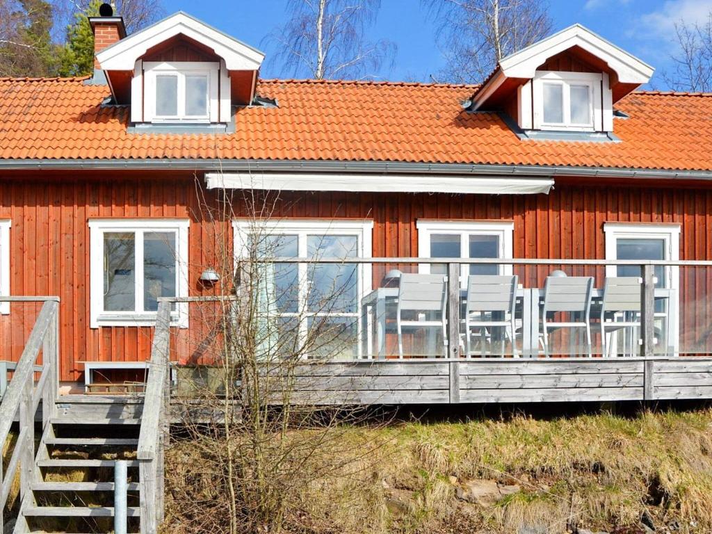 a red house with chairs on a deck at 8 person holiday home in HJÄLTEVAD in Hjältevad