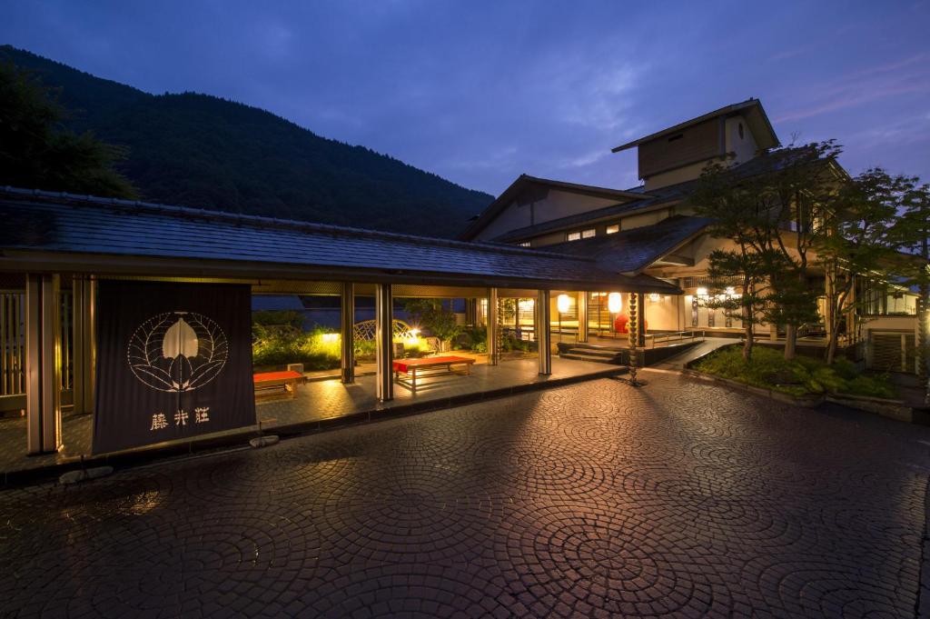 a building with a lit up courtyard at night at Fujiiso (Adult Only) in Takayama