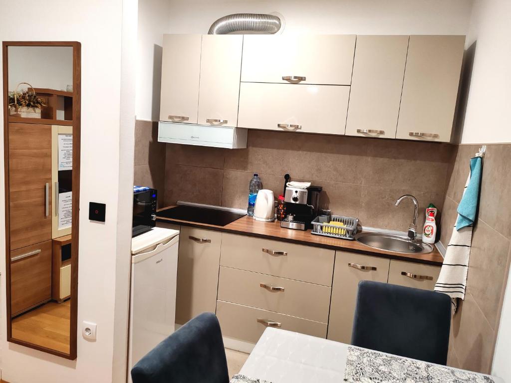 a small kitchen with white cabinets and a sink at Apartman Max in Modriča