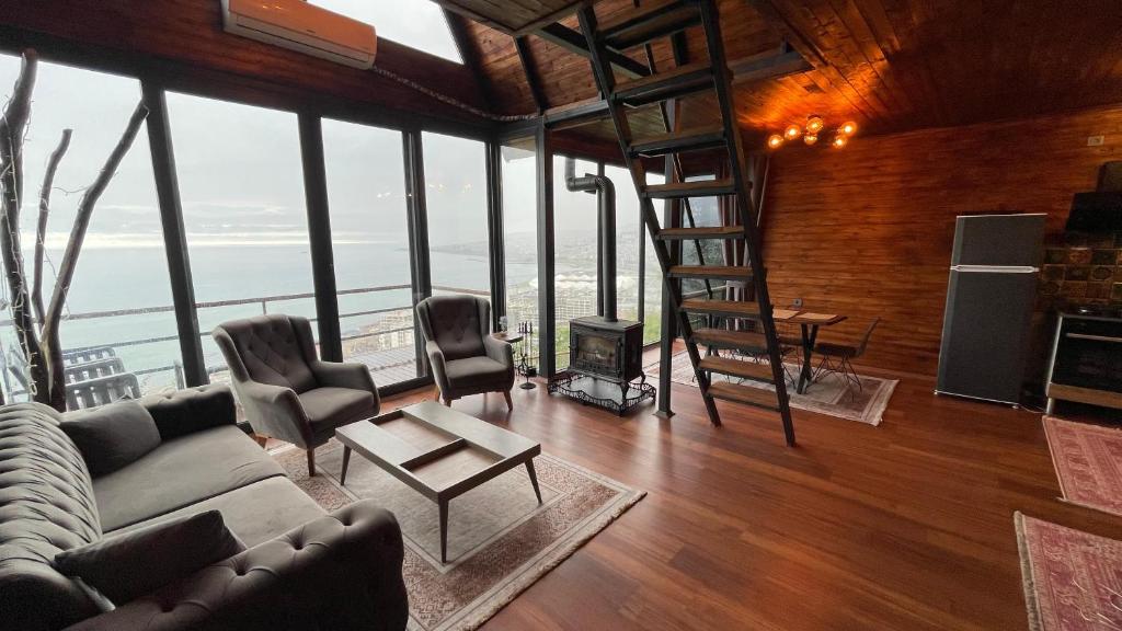 ein Wohnzimmer mit einem Sofa, Stühlen und einer Leiter in der Unterkunft Trabzon Silent Hill Bungalow in Trabzon
