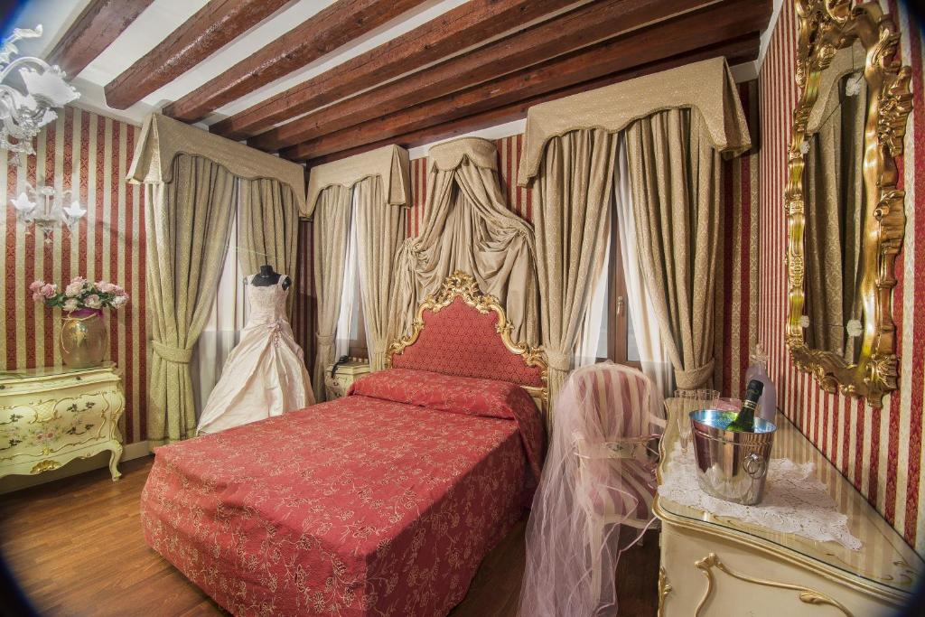 a bedroom with a bed with a red bedspread at Dimora Dogale in Venice