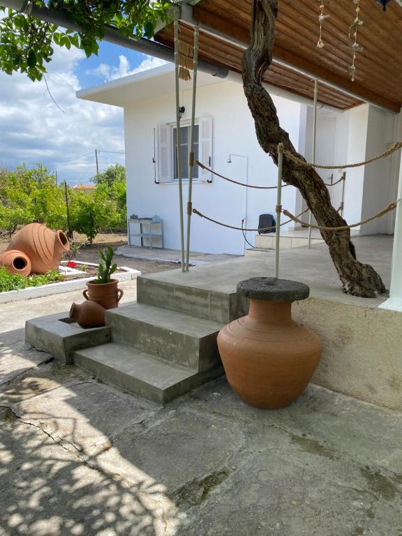 a group of vases sitting on steps in front of a house at Pedi’s house in Aspropótamos