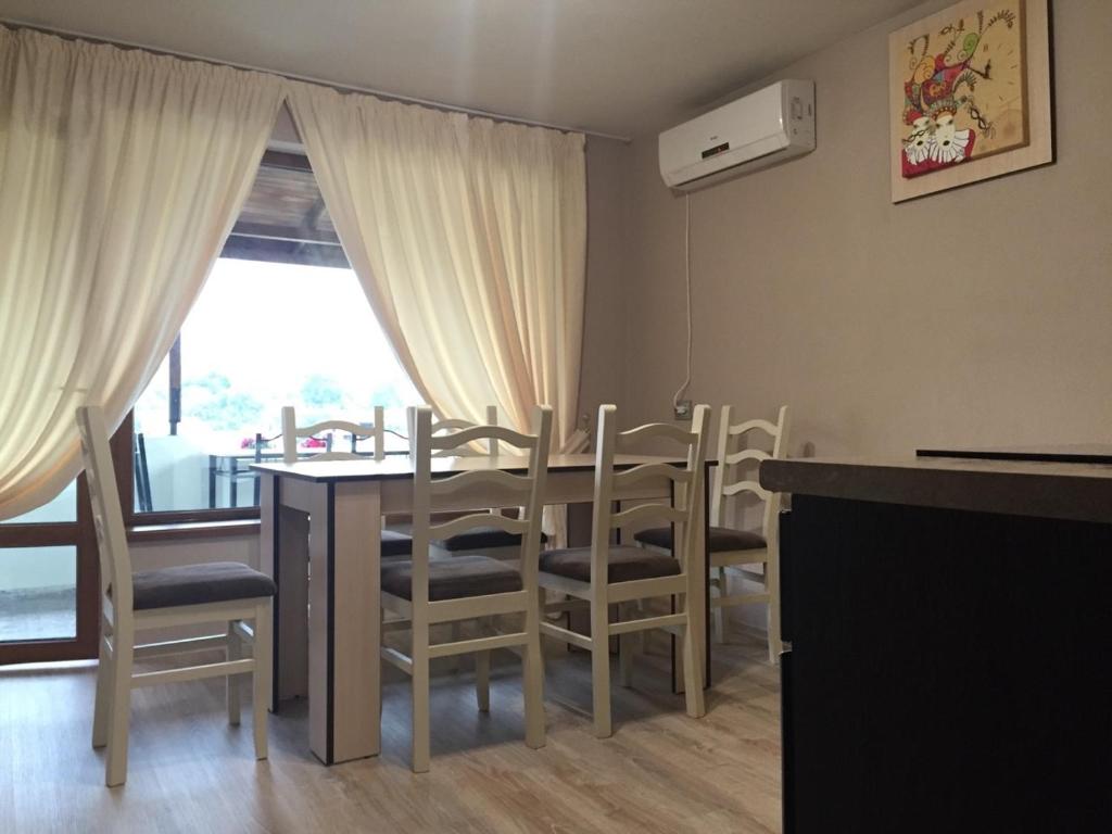 a dining room with a table and chairs and a window at Bora Apartment in Sandanski