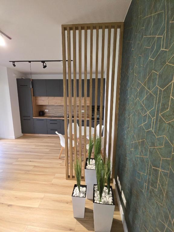 a living room with a table and potted plants at Apartament Park Trzy Stawy in Katowice
