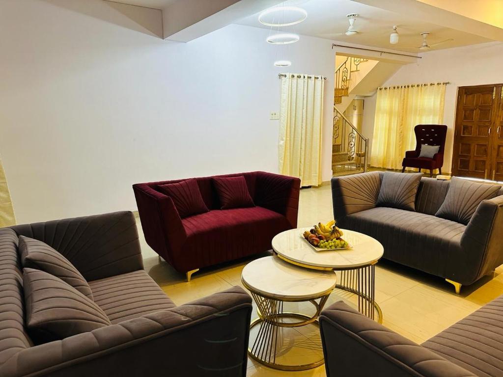 een woonkamer met banken en een salontafel bij Buddha Inn-An Enchanted Garden Villa in Varanasi