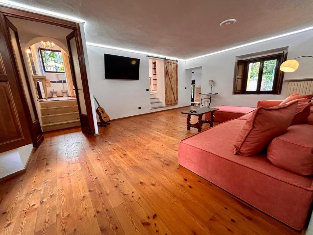 瓦雷澤的住宿－Kibilù - Via Virgilio，客厅设有红色的沙发和木地板