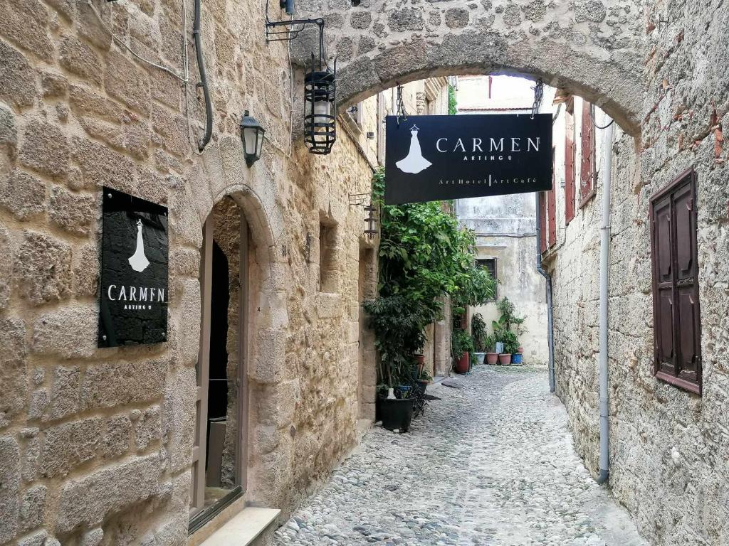an alley in an old stone building with a sign at Carmen Art Hotel in Rhodes Town