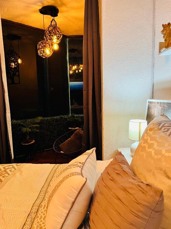 a bedroom with a bed with a chandelier and a window at Habitación Diamante in Orizaba