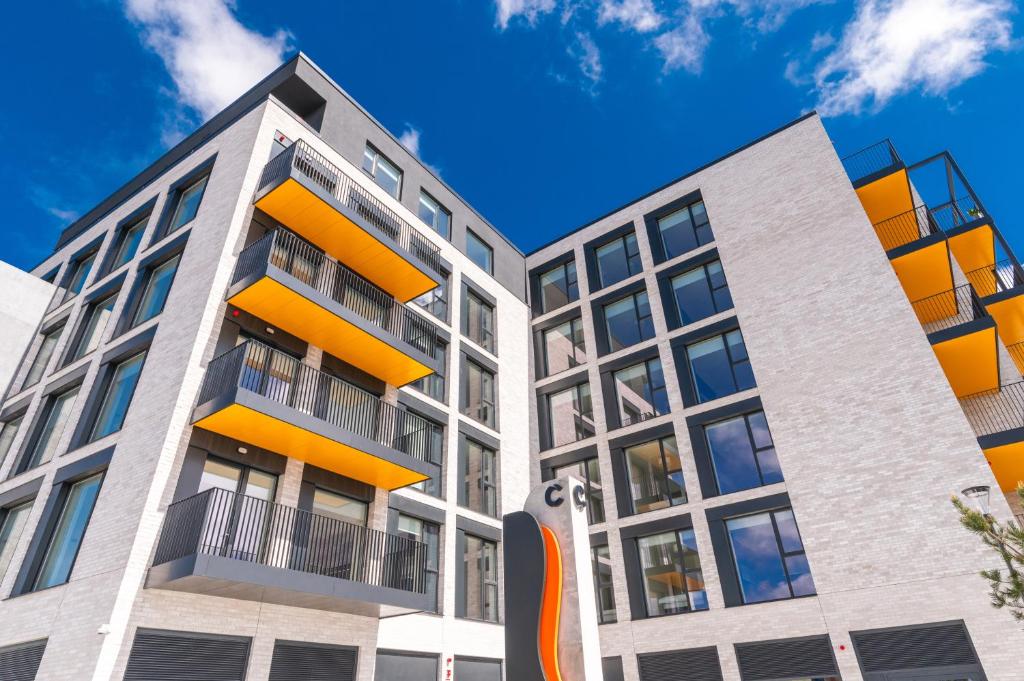 an apartment building with orange balconies on a blue sky at The Cornerstone Two by Dublin At Home in Dublin