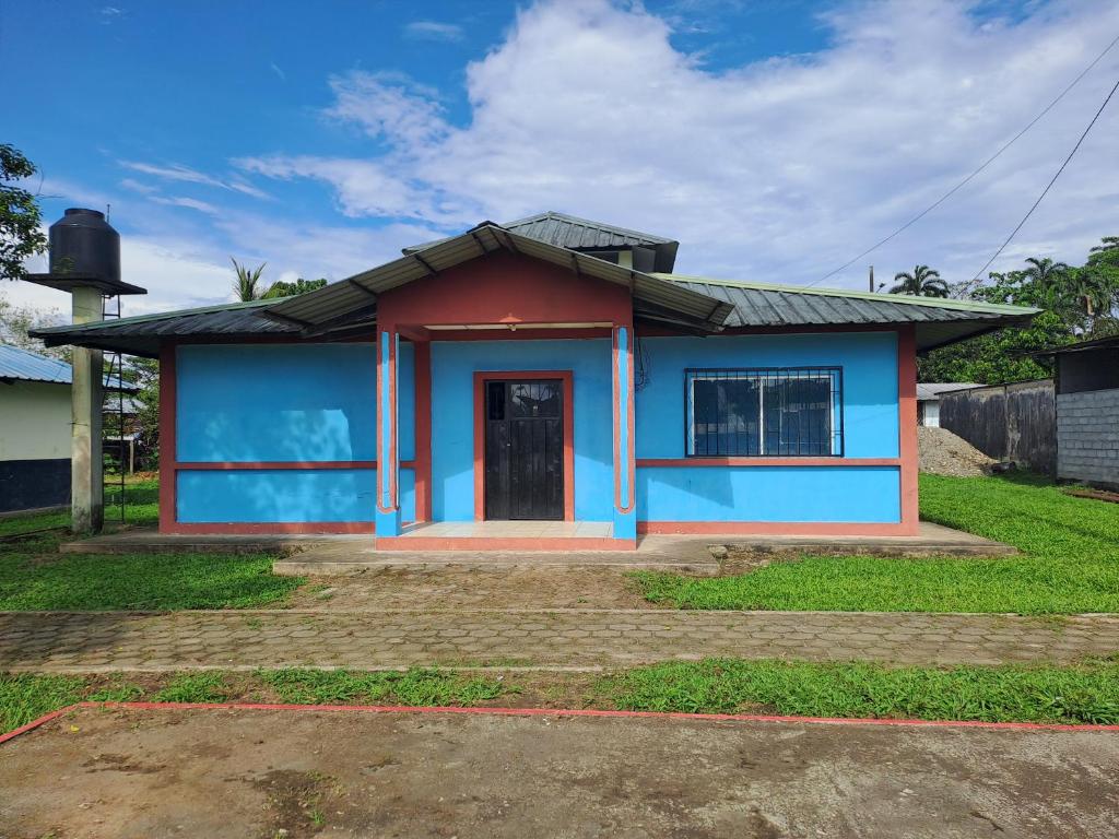 una pequeña casa de color azul y rojo en Hotel Turismo Asokilc, en Limoncocha