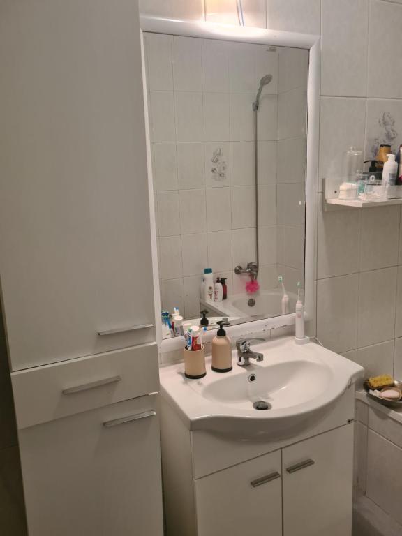 a white bathroom with a sink and a mirror at Quarto Santiago in Corroios