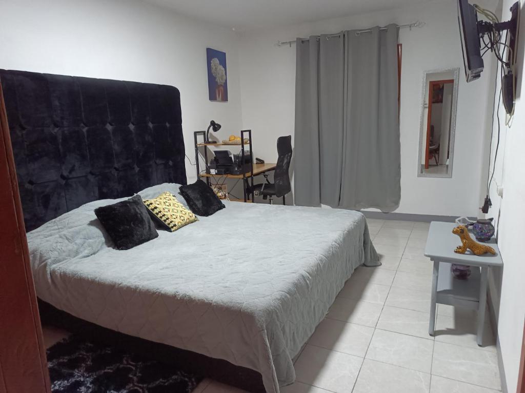 um quarto com uma cama com uma cabeceira preta em Hospedaje San Benito em San Cristóbal de Las Casas