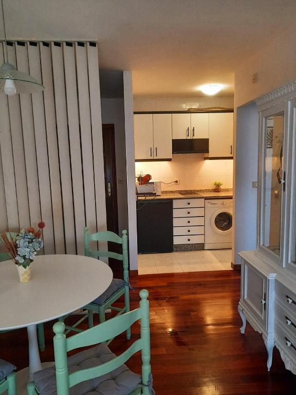 a kitchen with a table and a table and chairs at Apartamento En Camino - NEST Milladoiro in Milladoiro