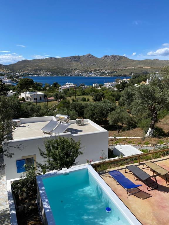 una piscina frente a una casa con vistas en The Velanidies - Οι Βελανιδιές en Agia Marina