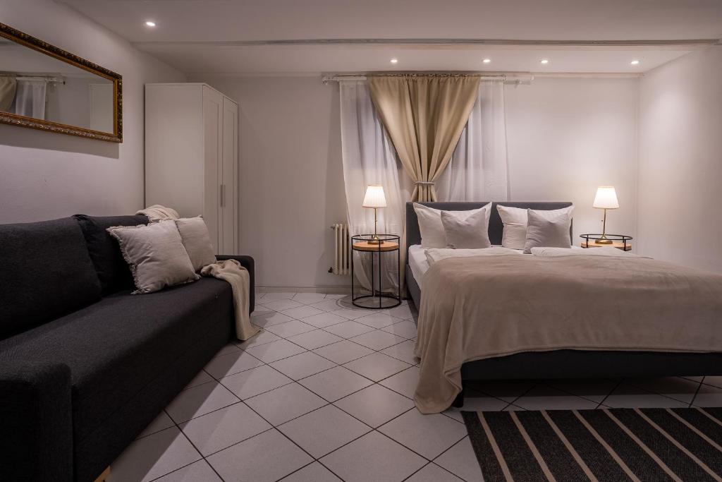 ein Hotelzimmer mit einem Bett und einem Sofa in der Unterkunft EPA Apartment - Swedish style Souterrain in Rust