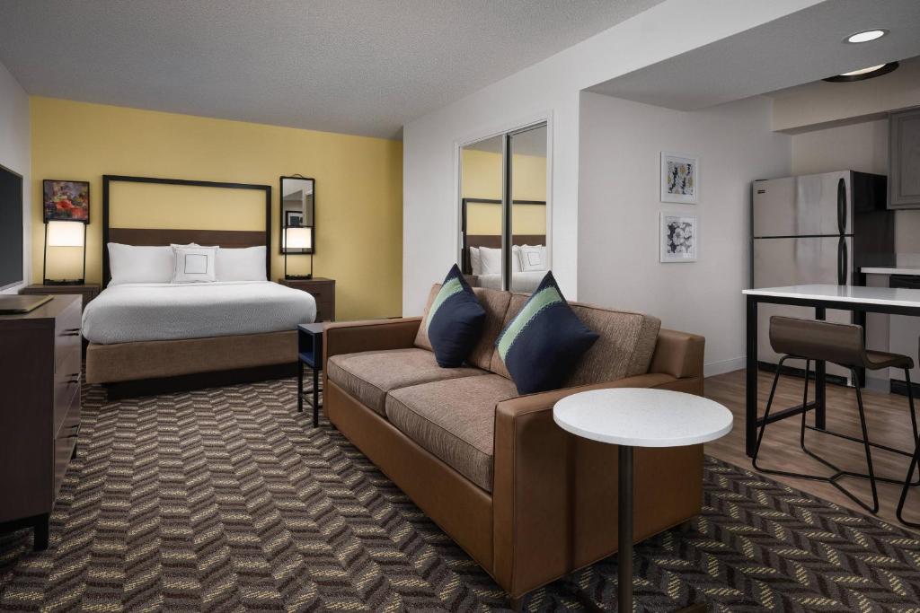 サニーベールにあるレジデンス イン サニーヴェール シリコンバレー IIのベッド、ソファ、テーブルが備わるホテルルームです。