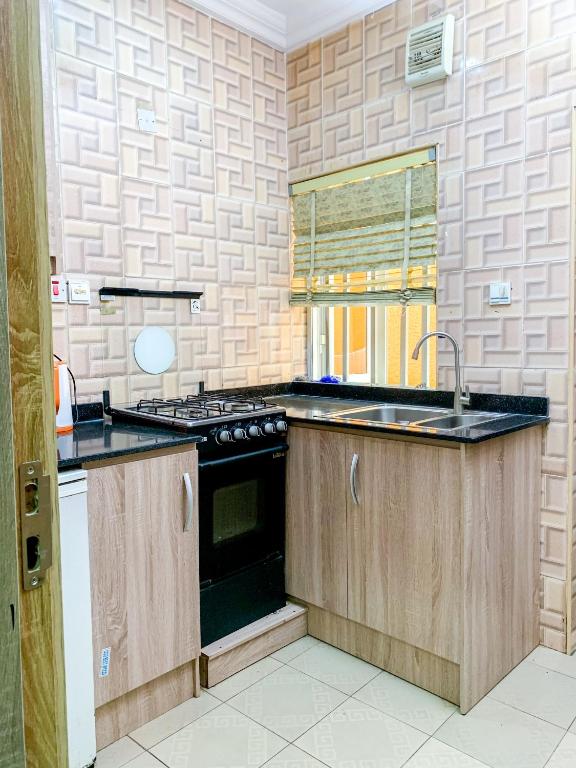 uma cozinha com um lavatório e um fogão em 24B Maye Ogunda em Lagos