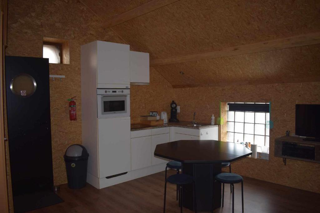 a kitchen with a table and a white refrigerator at Lî Stôle in Durbuy