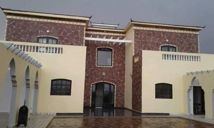 a large brick building with white and red at sidi kaouki ayt karoum in Sidi Kaouki