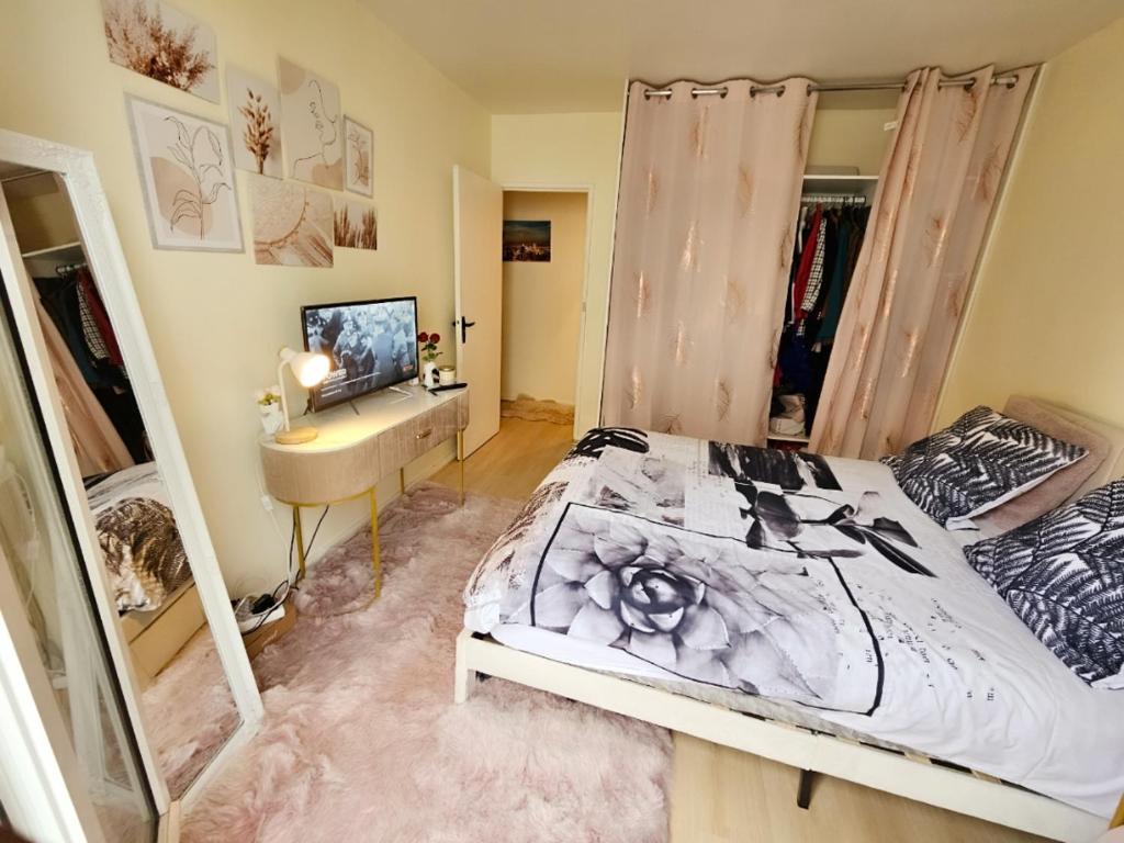 - une chambre avec un lit, un bureau et un miroir dans l'établissement Appartement proche de l'aéroport CDG & stade de France, à Aulnay-sous-Bois