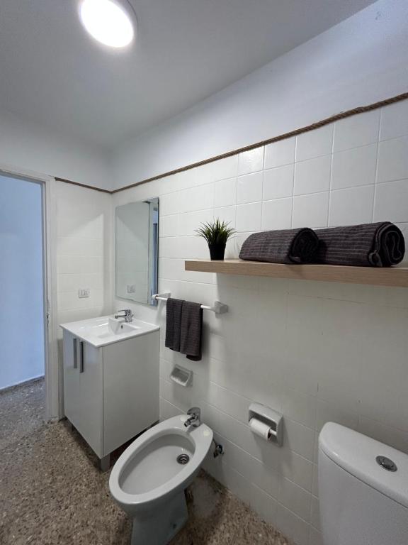 a white bathroom with a toilet and a sink at Médano Beach Blue in El Médano
