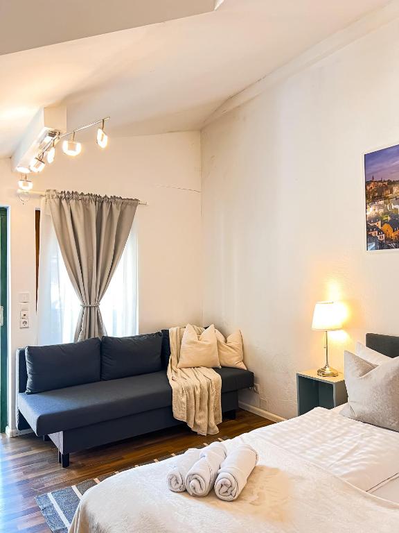 a living room with two beds and a blue couch at Studio Luxembourg - EPA in Rust