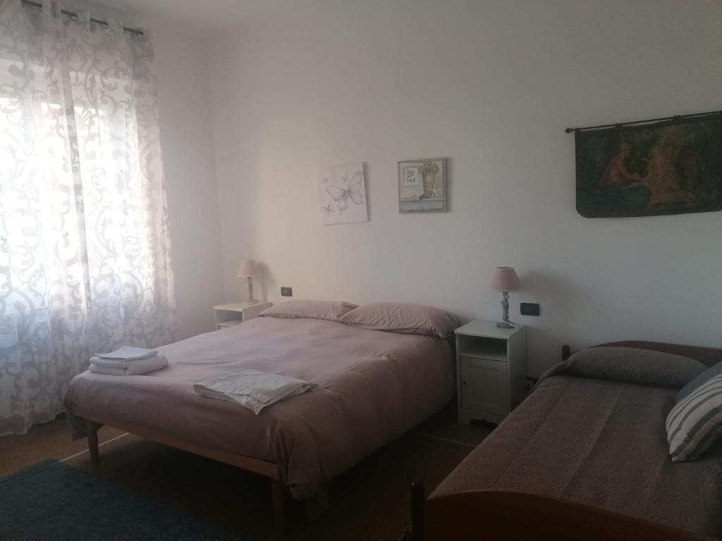 - une chambre avec 2 lits et une fenêtre dans l'établissement La casa di Rossella - Genova, Quarto mare, à Gênes