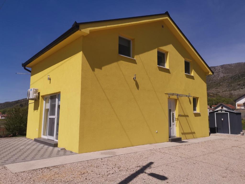 una casa amarilla con un amarillo en Žuta kuća, en Grude