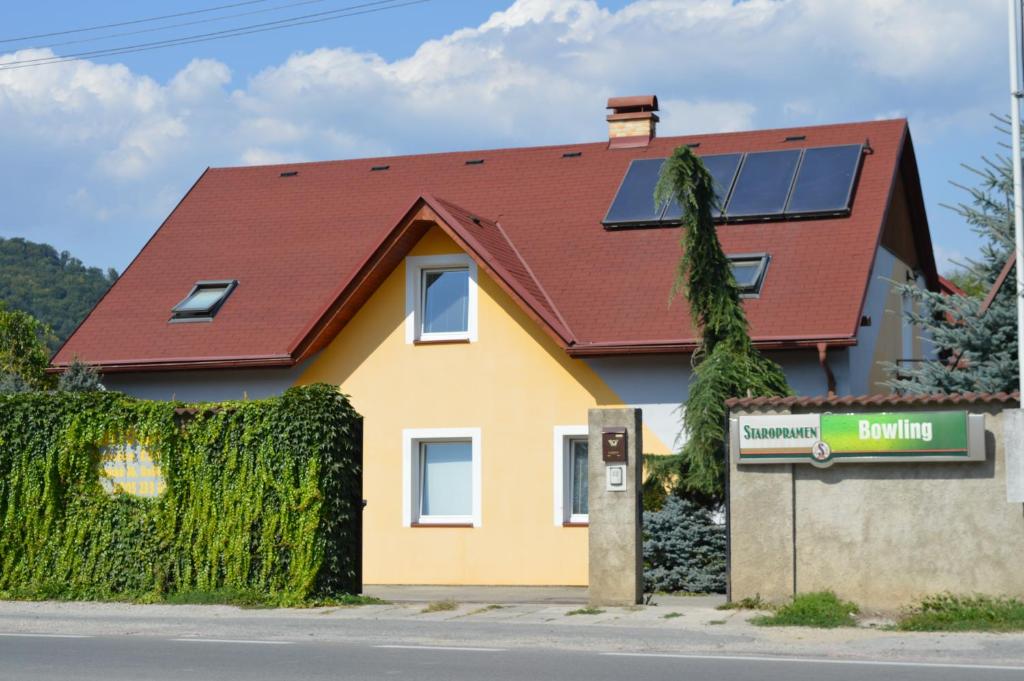 een huis met een rood dak en een gebouw met een bord bij Davi Penzion & Bowling in Rožňava