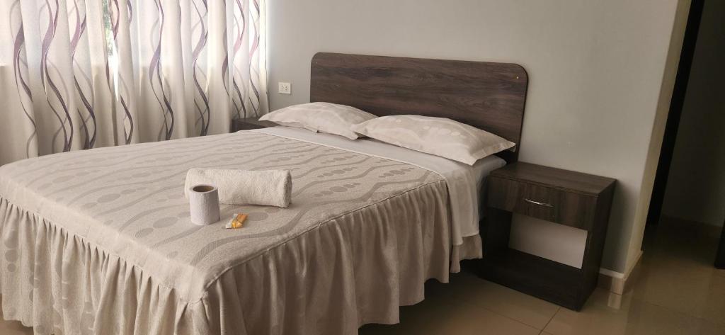Una cama con dos almohadas y una toalla. en Hotel Gran Marquez en Moquegua