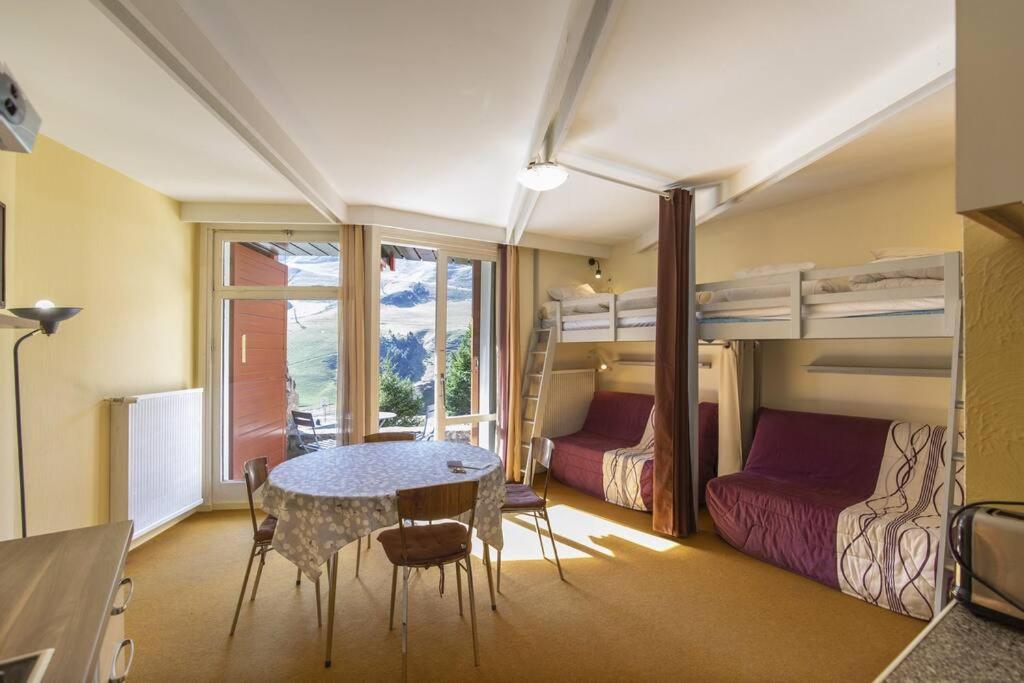 - une chambre avec une table et une chambre avec des lits superposés dans l'établissement Petit cocon au cœur de la Mongie, à Bagnères-de-Bigorre