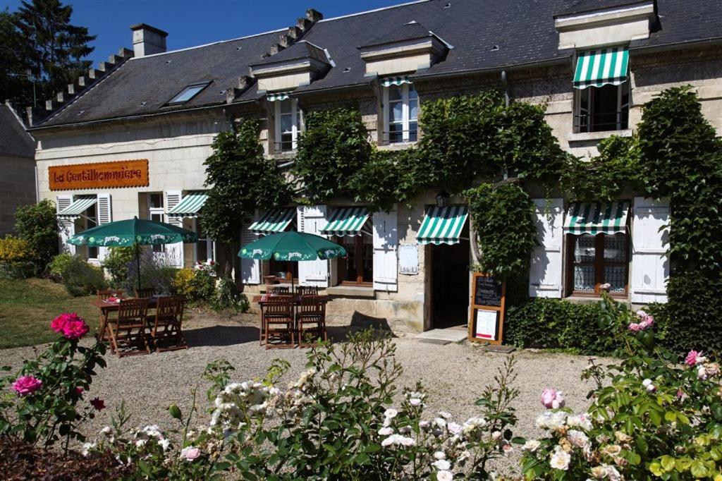 a building with chairs and umbrellas in front of it at Ma Gentilhommière in Croutoy