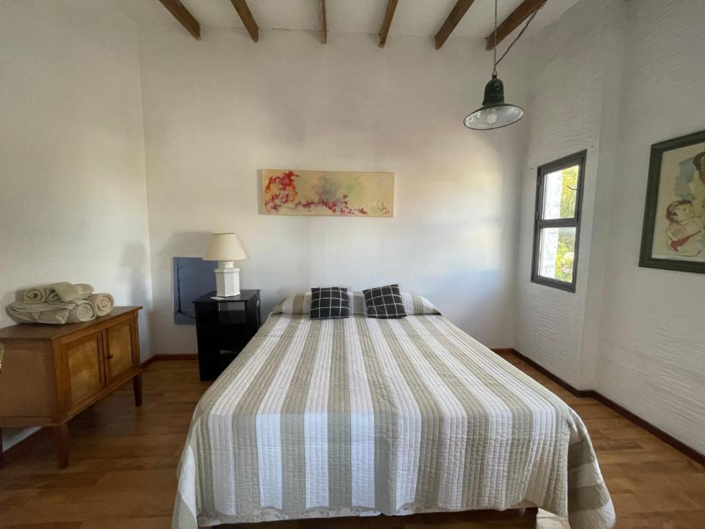1 dormitorio con 1 cama con manta a rayas en Departamento familiar en Coronel Suárez