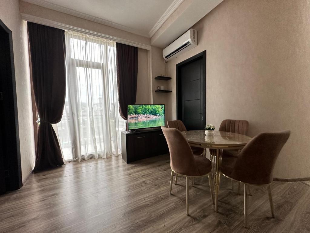 uma sala de estar com uma mesa e uma televisão em Apartment 45 em Tbilisi