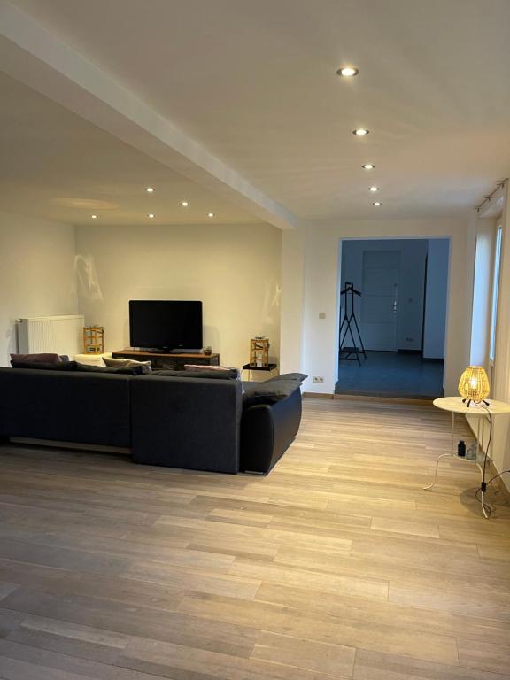a living room with a couch and a television at Hele mooie vakantiewoning nabij Brugge in Damme
